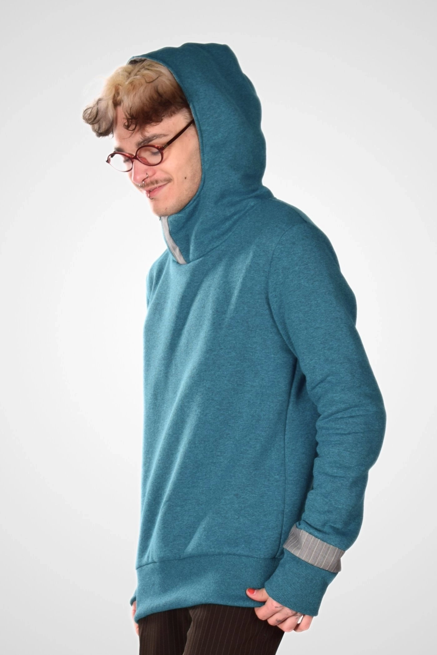 Kapuzenpulli in Petrol von Potatoes seitlich gezeigt mit Kapuze getragen