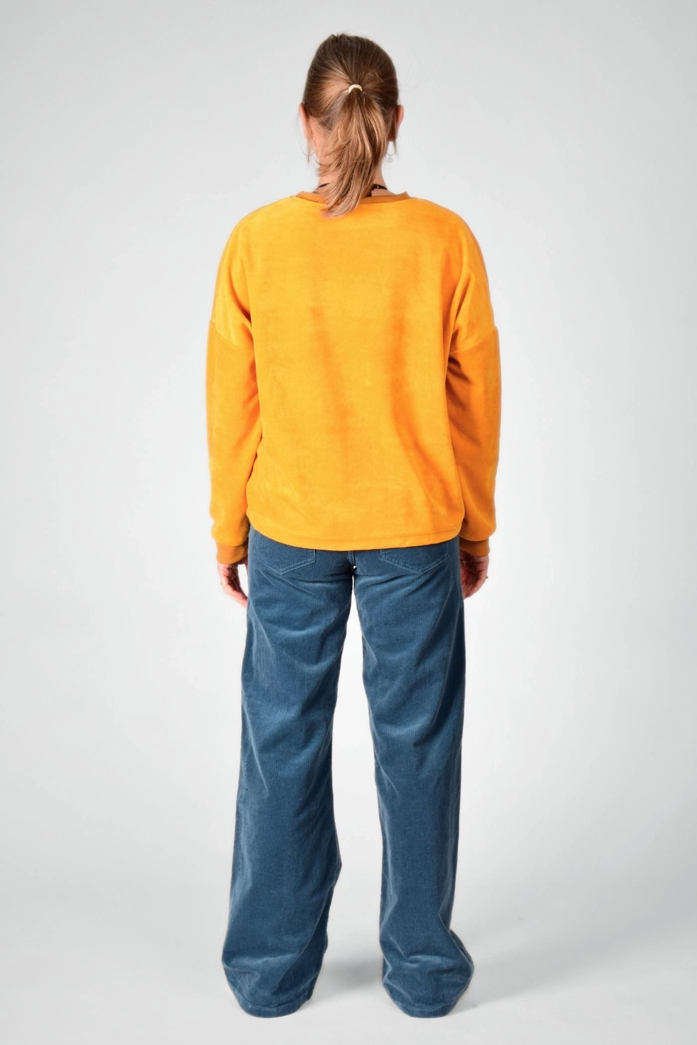 Samtpullover "Tia" in Gelb von hinten mit Cordhose "Marlene"