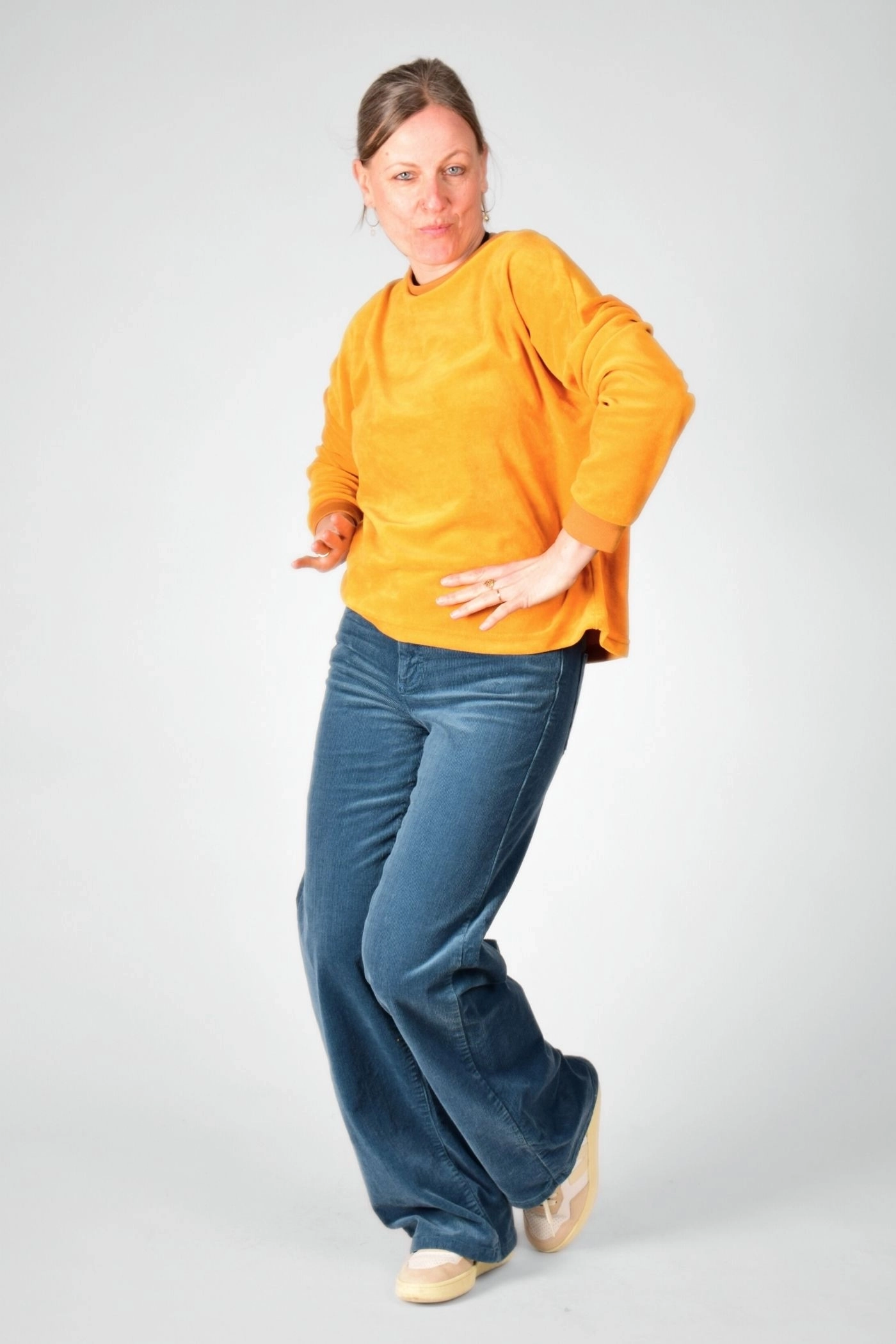 tanzendes Model mit gelbem Pullover "Tia" aus Nicki Samt von "Potatoes"