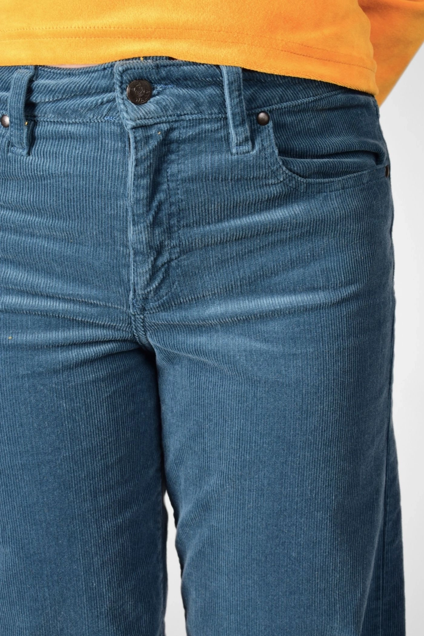 Detailansicht mit Reißverschluss und Knopf der nebelblauen Cordhose