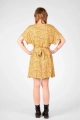 Model mit Kleid "Fleur" in kurzarm und bunter Blumenwiese auf Gelb von hinten