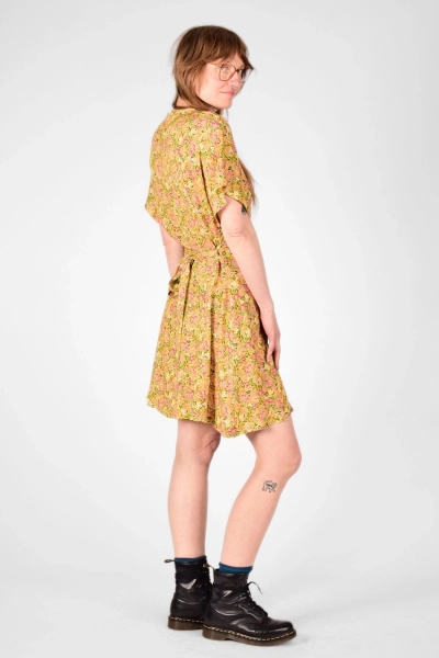 Model mit Kleid "Fleur" in kurzarm und bunter Blumenwiese auf Gelb von der rechten Seite