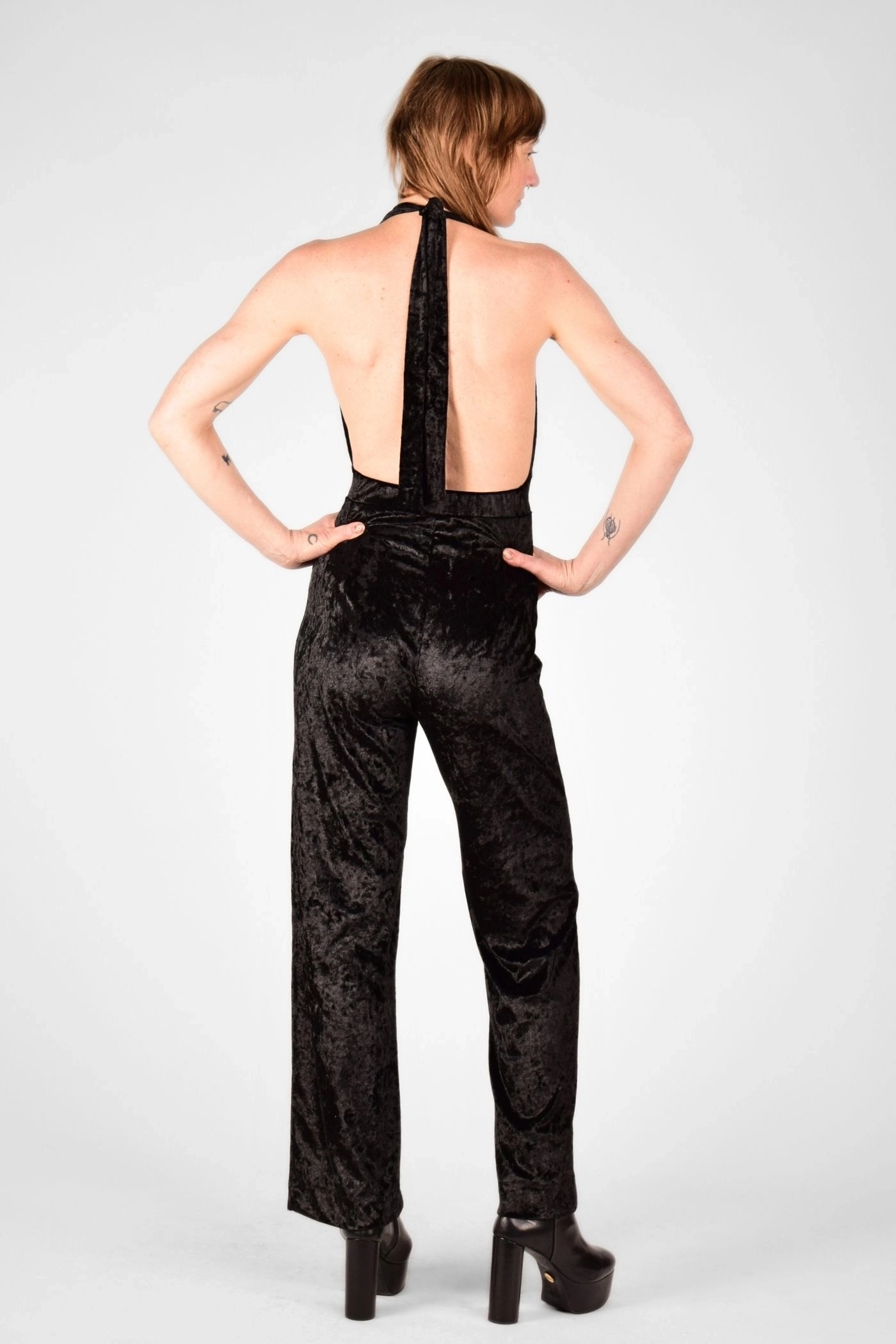 Model mit Jumpsuit "Florence" in schwarz aus Pannesamt von hinten