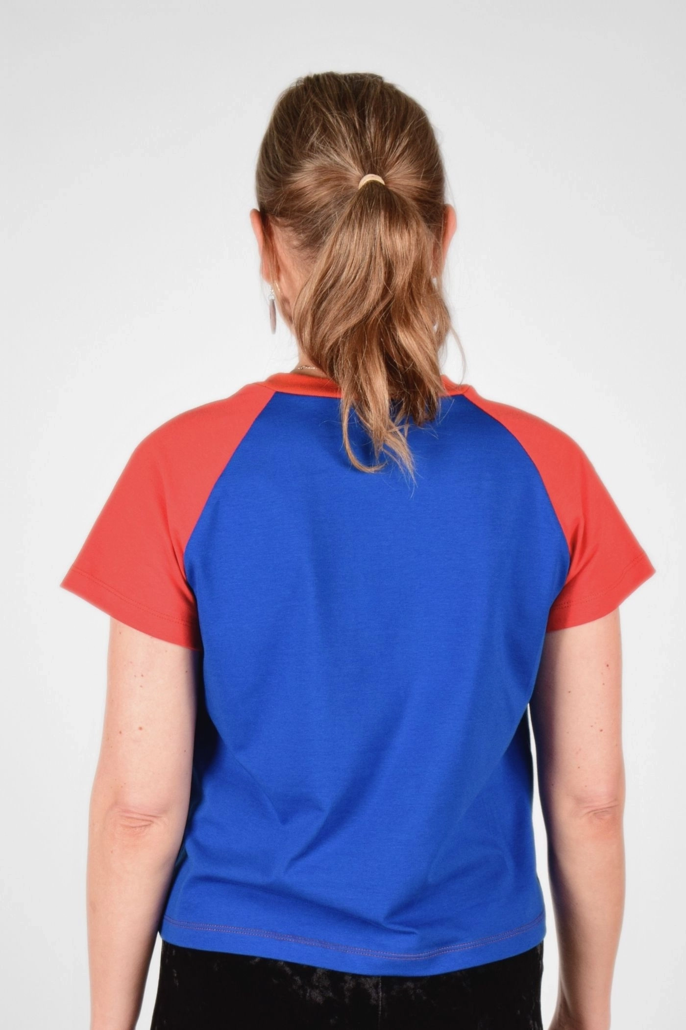 Rückansicht von T-Shirt "Sista" im Raclan Schnitt blau und rot