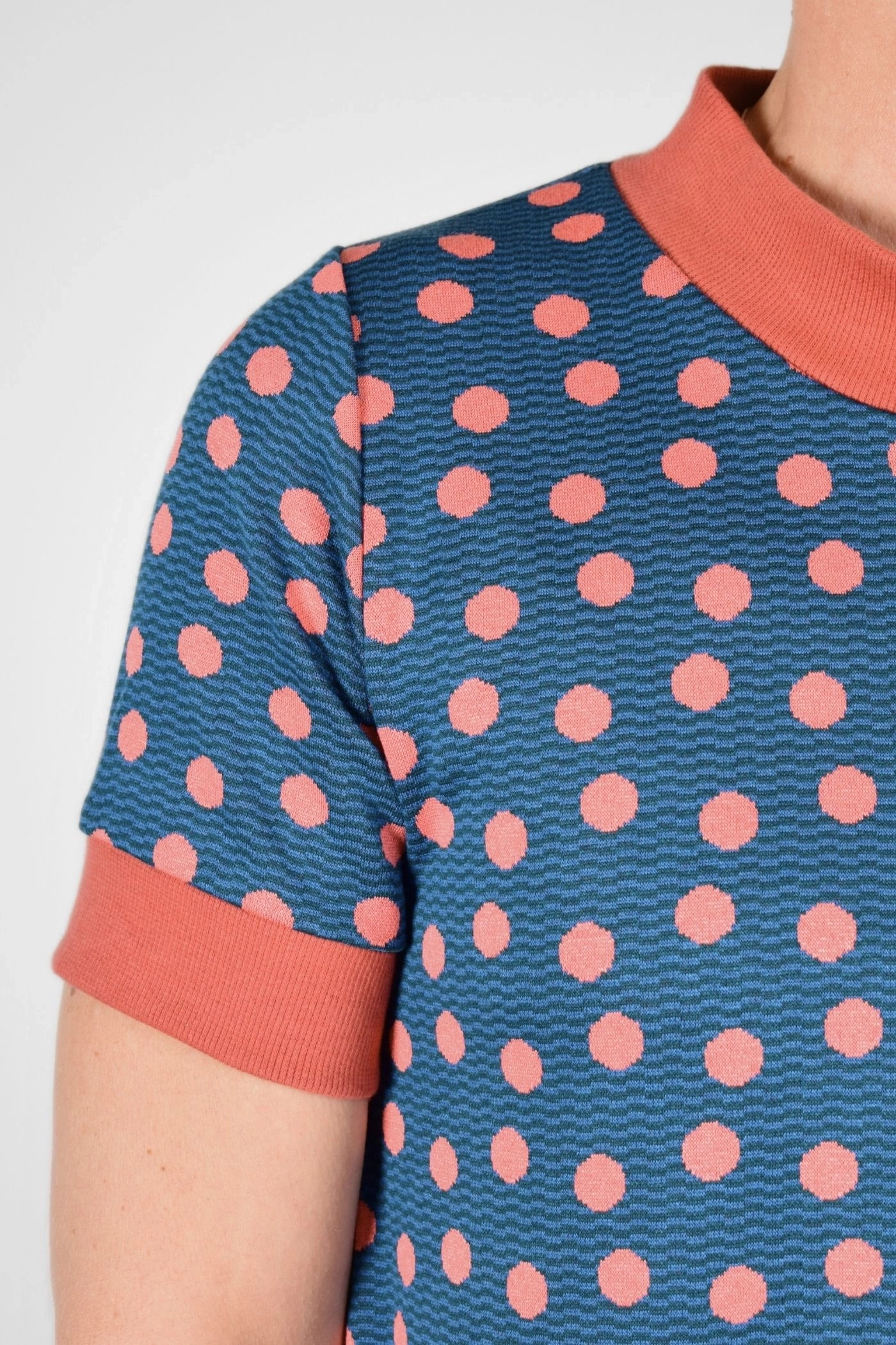 Detailansicht auf Ärmel von petrolfarbenes Kleid mit lachsfarbenen Punkten
