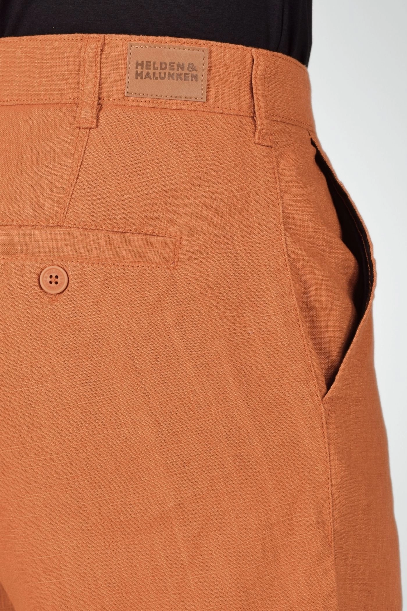 Detailansicht des Markenschildes am Bund der Chino Hose "Konrad" aus Leinen in curry